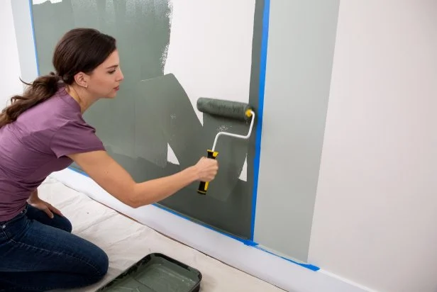 The next step in this DIY bold bar project is to paint the darker of the two colors on the wall after re-taping the border.
